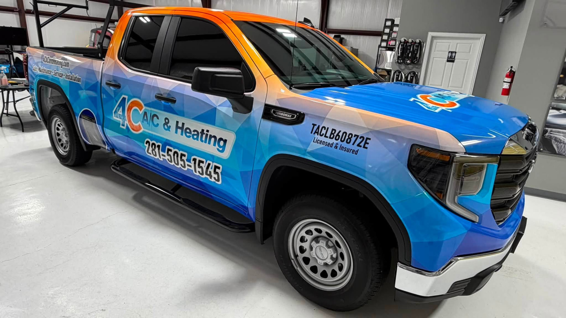 GMC Sierra in a blue and orange 4C A/C & Heating commercial wrap