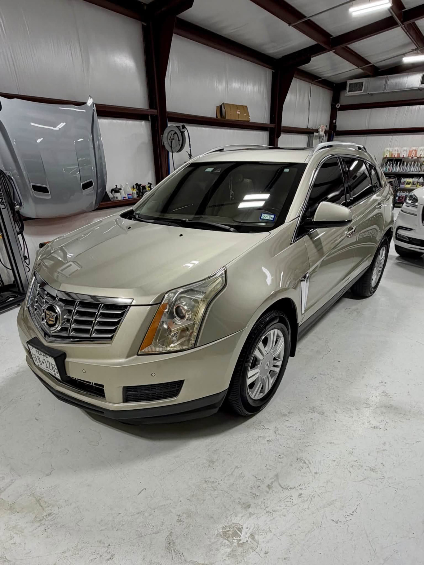 Champagne Cadillac SRX after a full maintenance detail in the studio